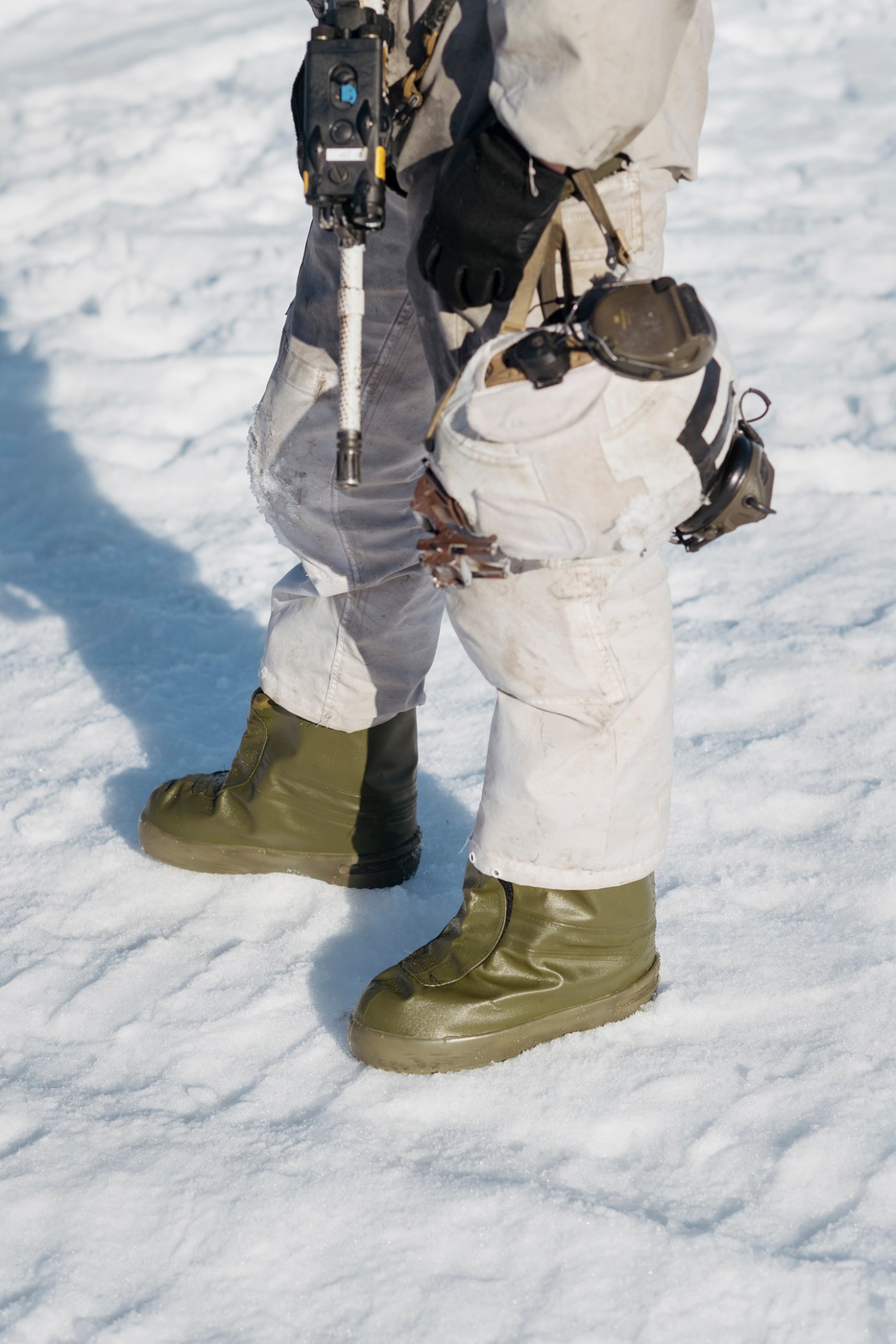 Close-up of waterproof combat boots worn by a Norwegian soldier standing in snow.