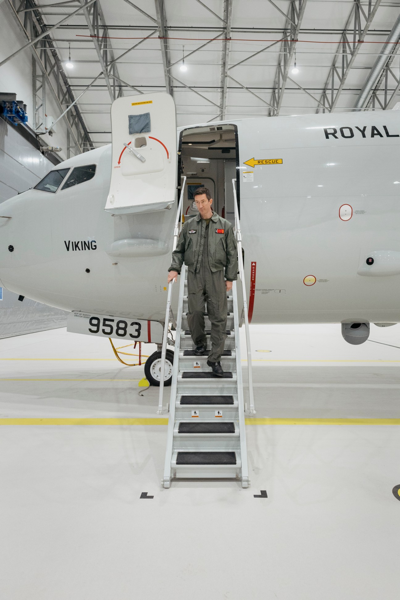 Norwegian naval officer Per Jørgen Tiller descending airplane stairs from Boeing P-8A Poseidon maritime surveillance aircraft.