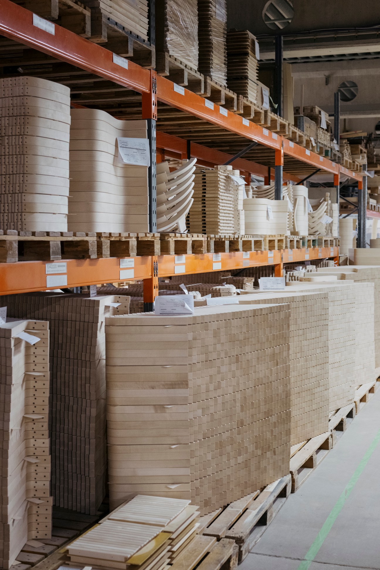 Stacks of timber planks arranged outside the Artek factory, showing the raw material storage