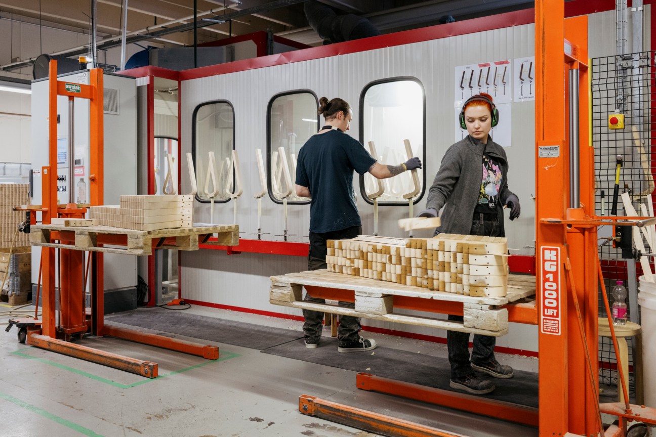 Workers on the Artek production line assembling wooden furniture components in the factory