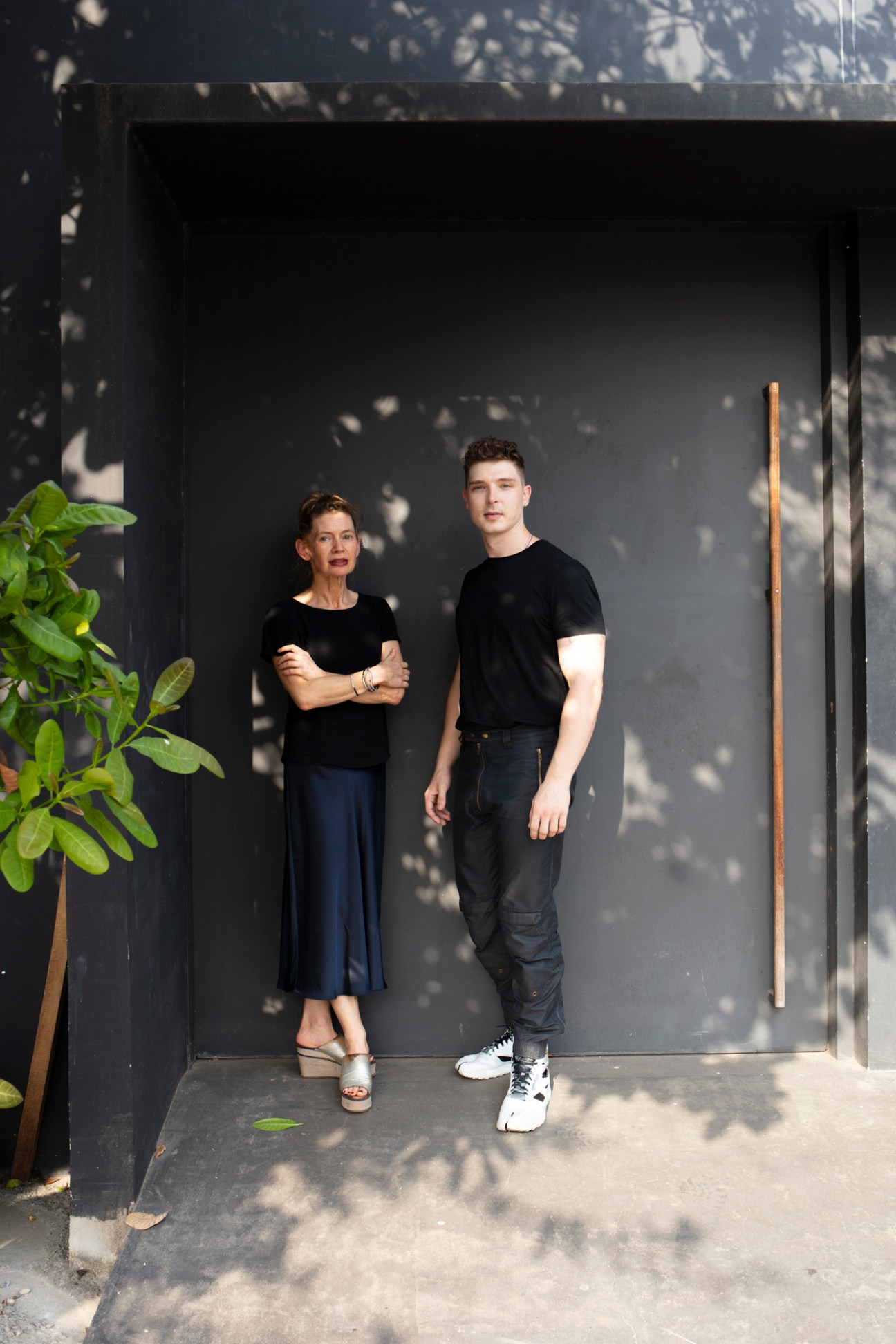 Baerbel Mueller and Juergen Strohmayer standing together outside a modern building with dappled shadows