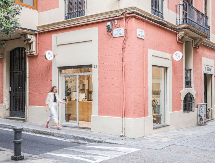 Exterior corner view of Coush Armó bakery in Barcelona's Gràcia neighbourhood with pink and white facade