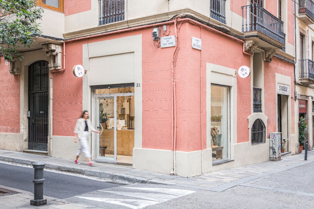 Exterior corner view of Coush Armó bakery in Barcelona's Gràcia neighbourhood with pink and white facade