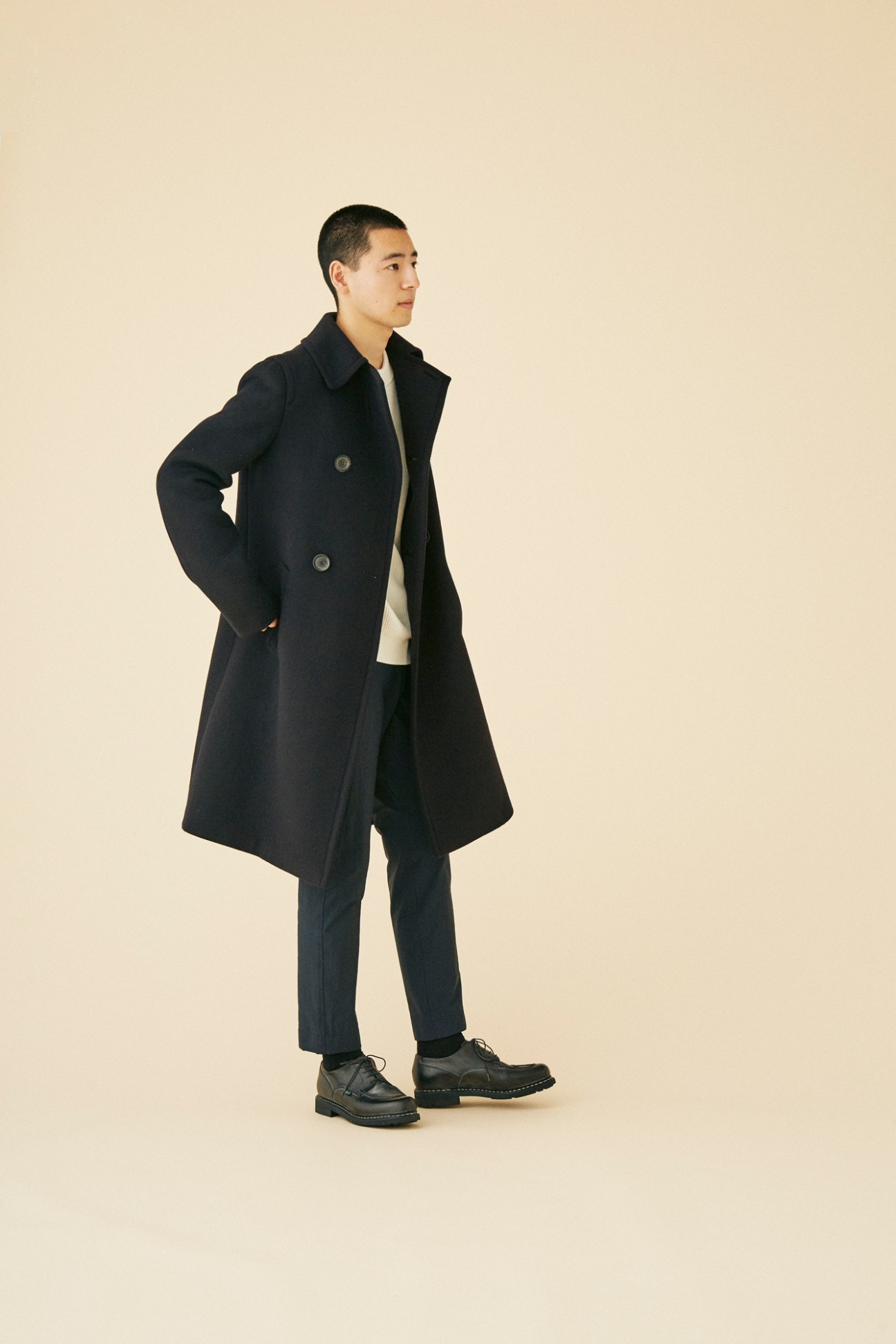 Man wearing sophisticated Prada coat in minimalist setting