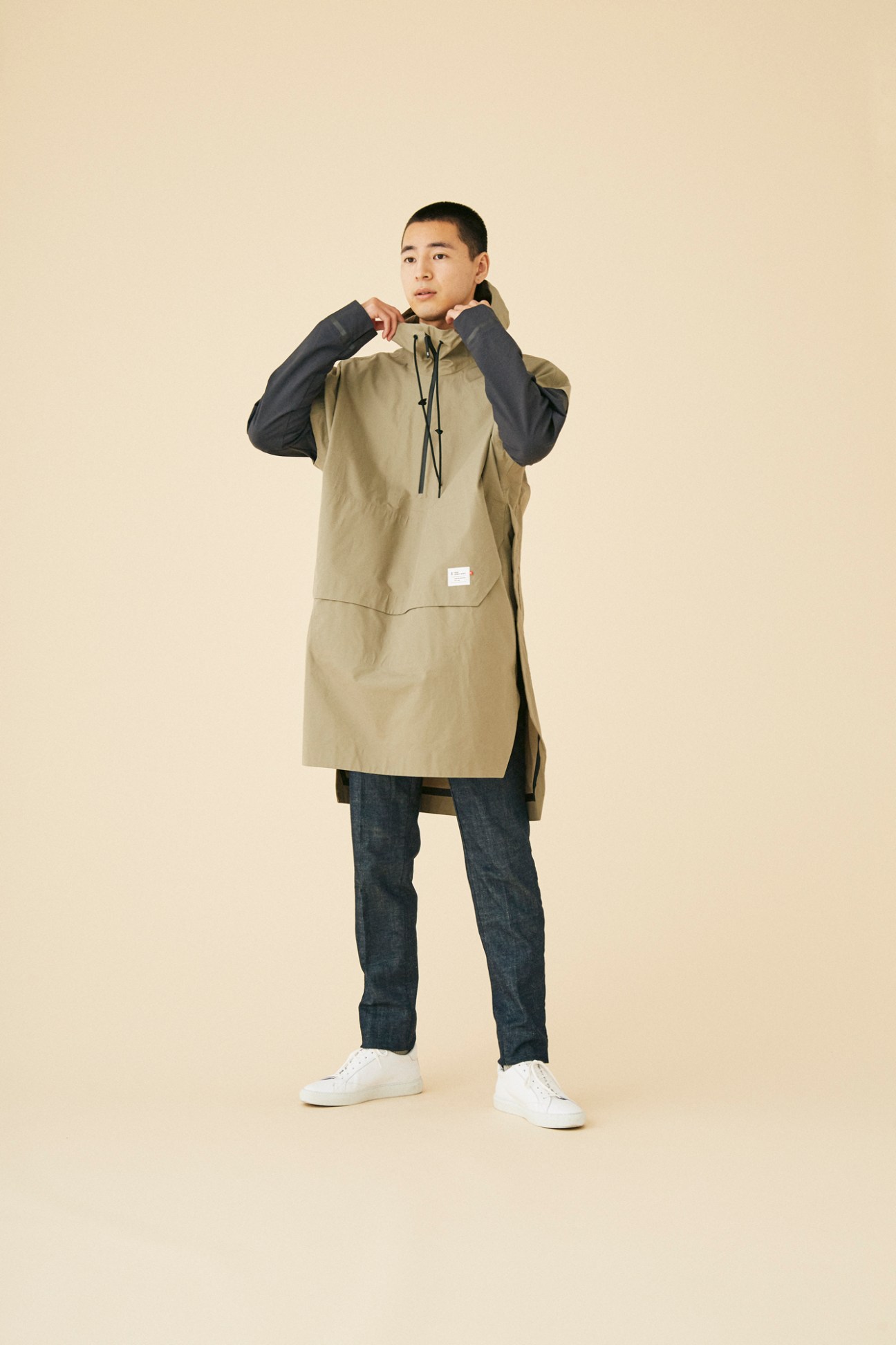 Man wearing performance jacket by On in clean studio setting