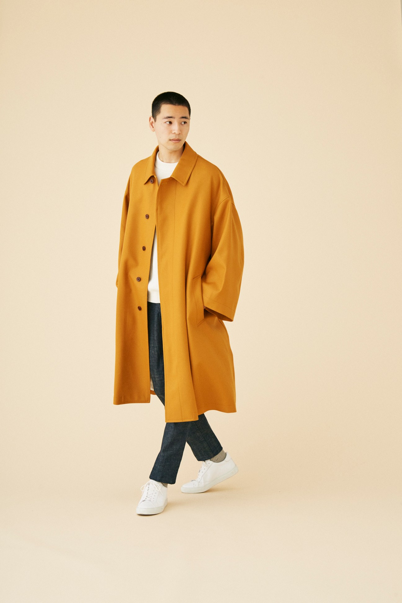 Man wearing contemporary coat by Graphpaper in minimalist setting
