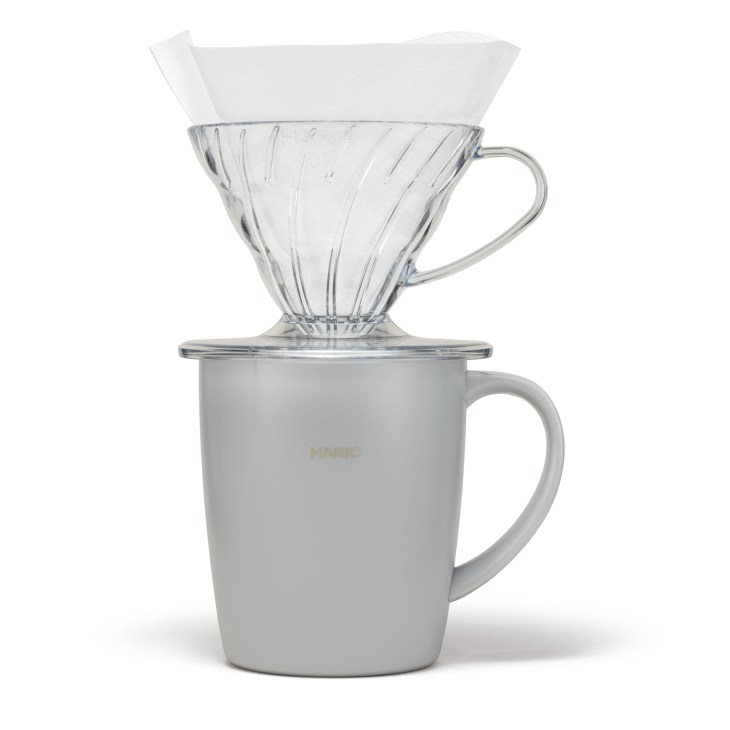 Hario coffee set with glass dripper, white ceramic mug and paper filters.
