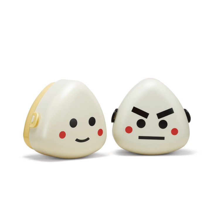 Two cute egg-shaped onigiri holders by Hakoya with happy and angry faces, one cream-colored with yellow handle.