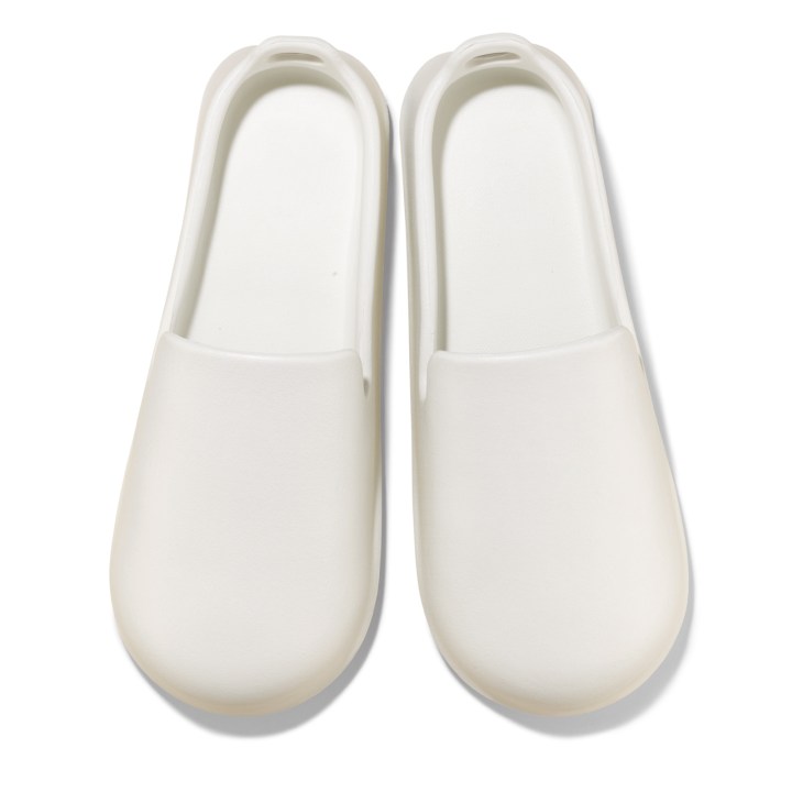 Pair of white Marna bathroom slippers with slip-on design viewed from above.