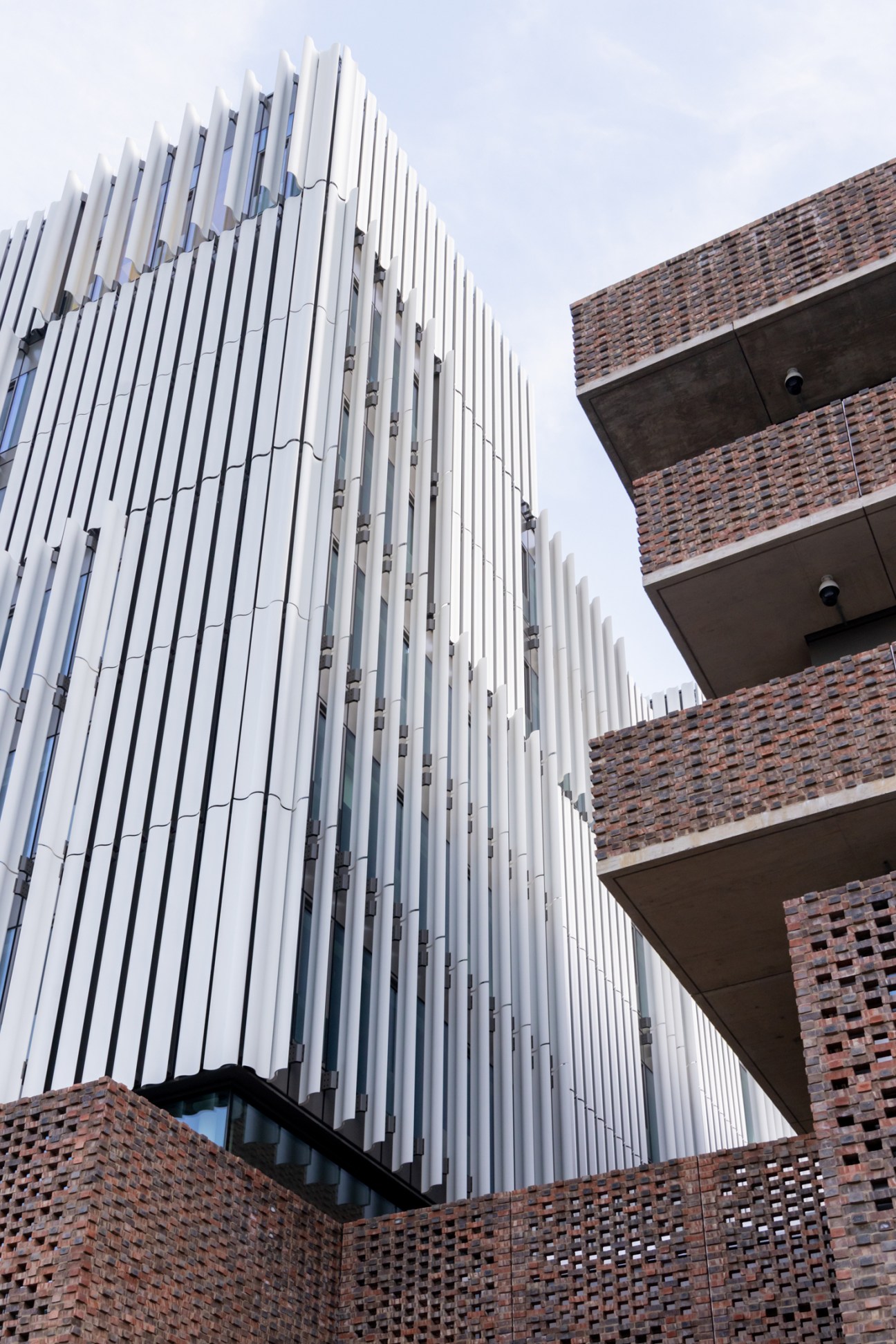 Students using balcony spaces at the RCA Rausing building with views of the surrounding Battersea neighborhood