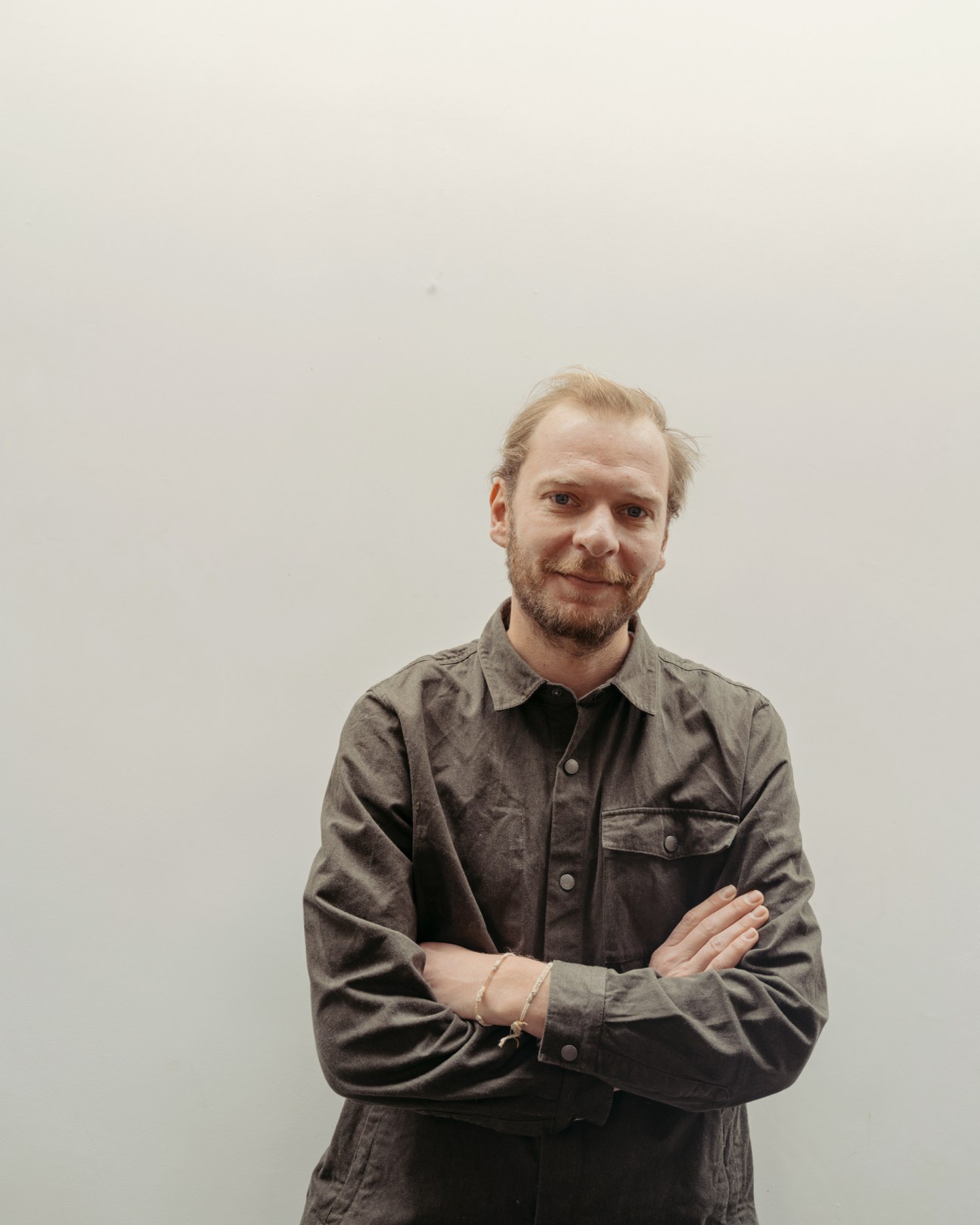 Mathieu Martin Delacroix, artistic director of 'JDD Magazine', standing with arms crossed wearing a grey shirt