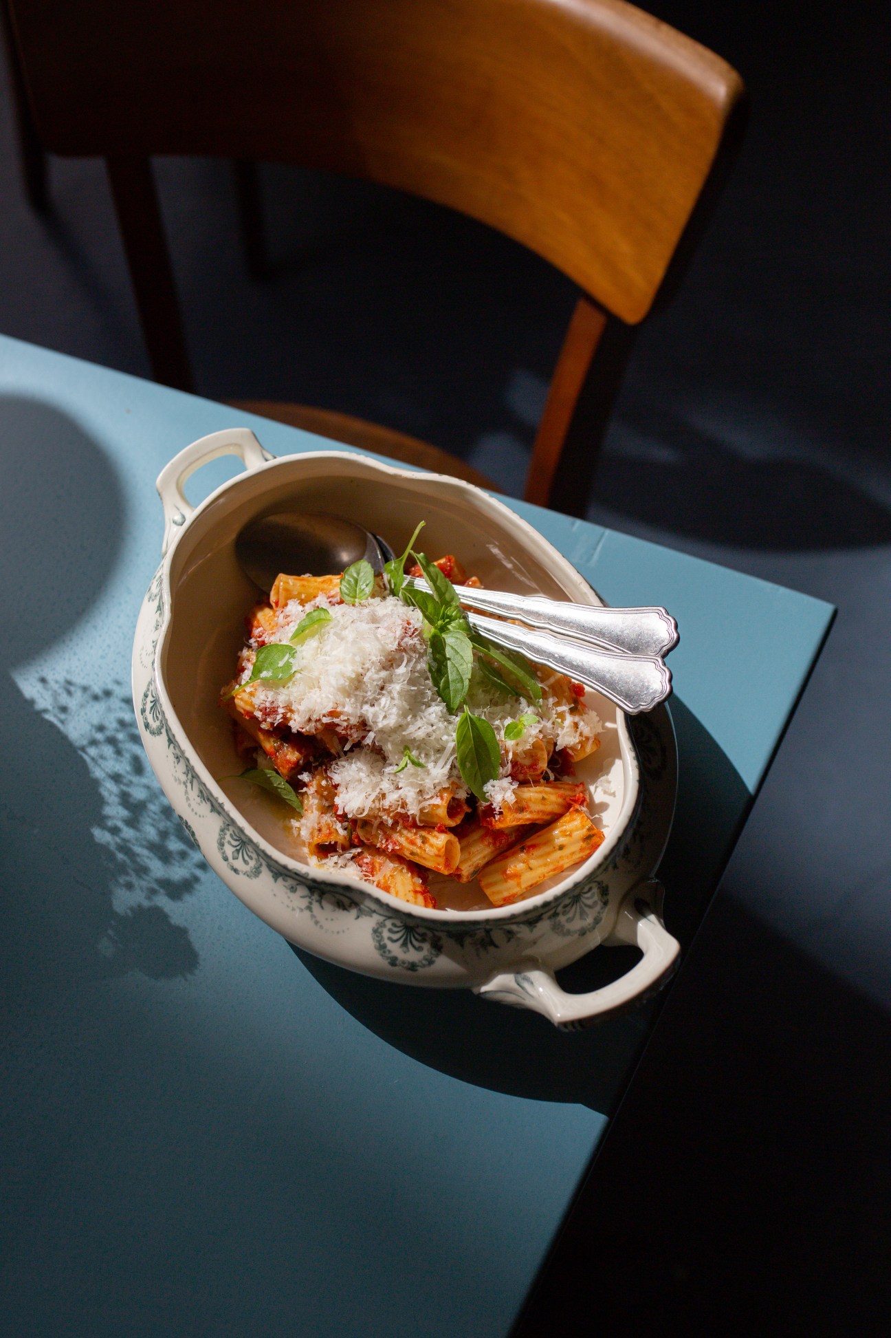 Pasta dish with tomato sauce, parmesan cheese and fresh basil served in decorative ceramic bowl at Pianoterra restaurant