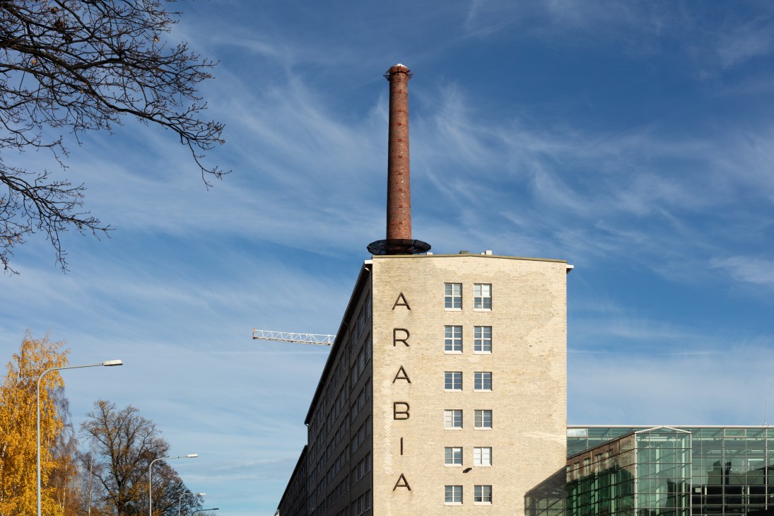 The Arabia factory building with tall brick chimney and 'ARABIA' lettering on its facade in Helsinki.