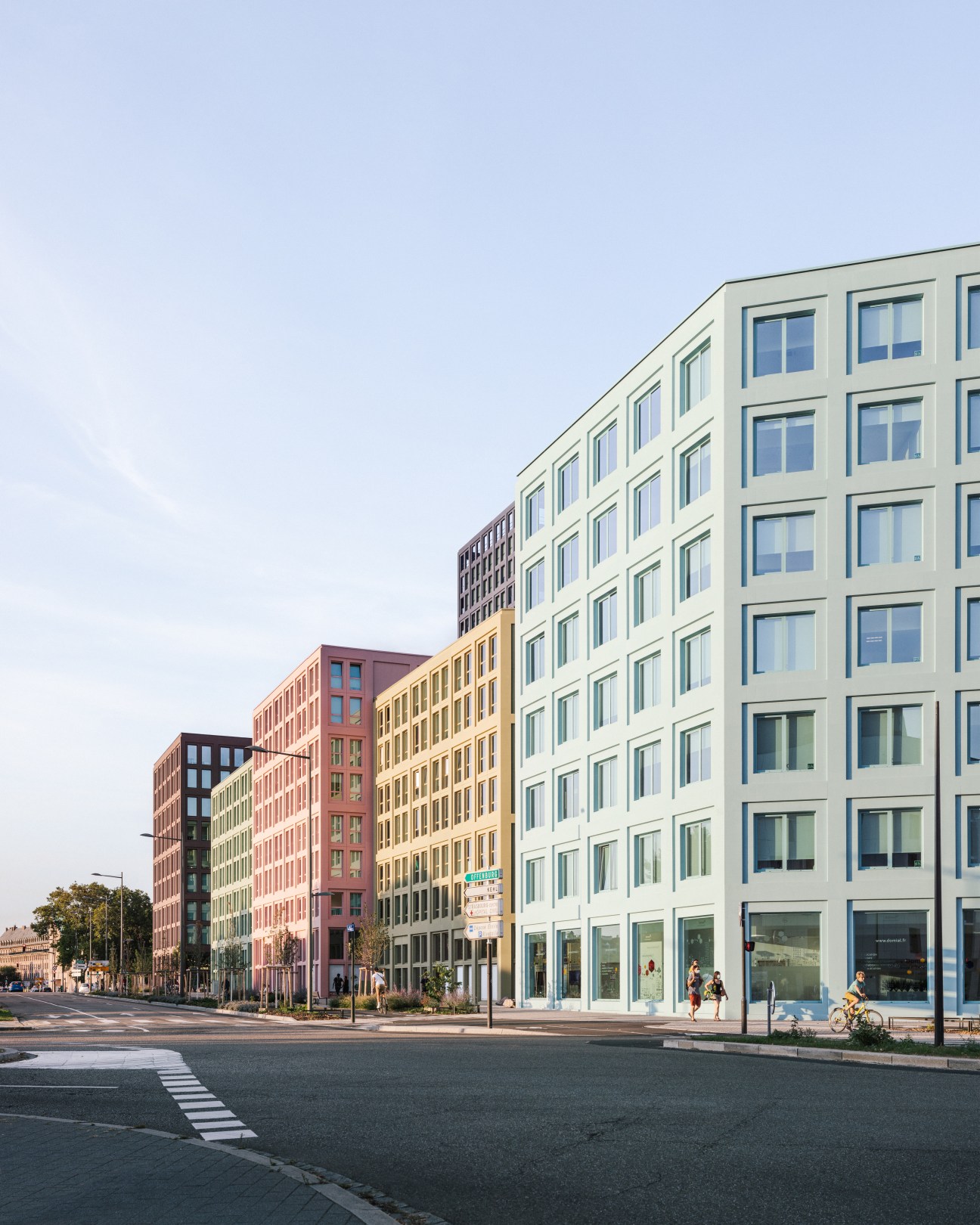 Modern residential building with colorful facade blocks in different hues including white, yellow, red and pink