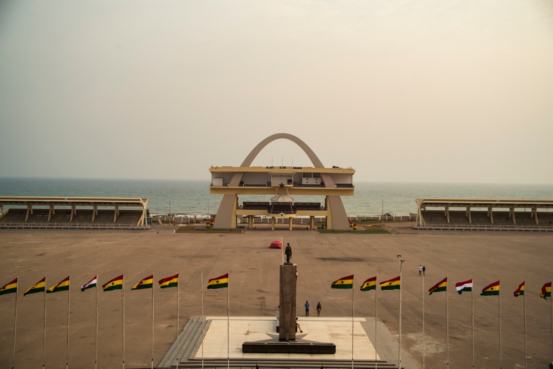 Black Star Square in Accra with Independence Arch, monument, and Ghanaian flags during golden hour