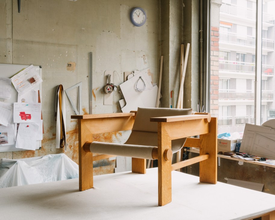 Studio Haos furniture pieces including ceramic, brass and glass table lamps with wooden seating in workshop setting