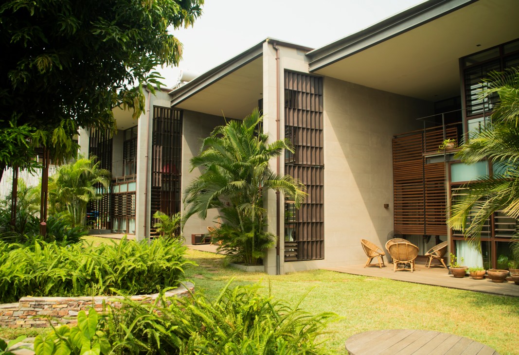 Modern residential buildings with palm trees and communal gardens at Legon City Lofts