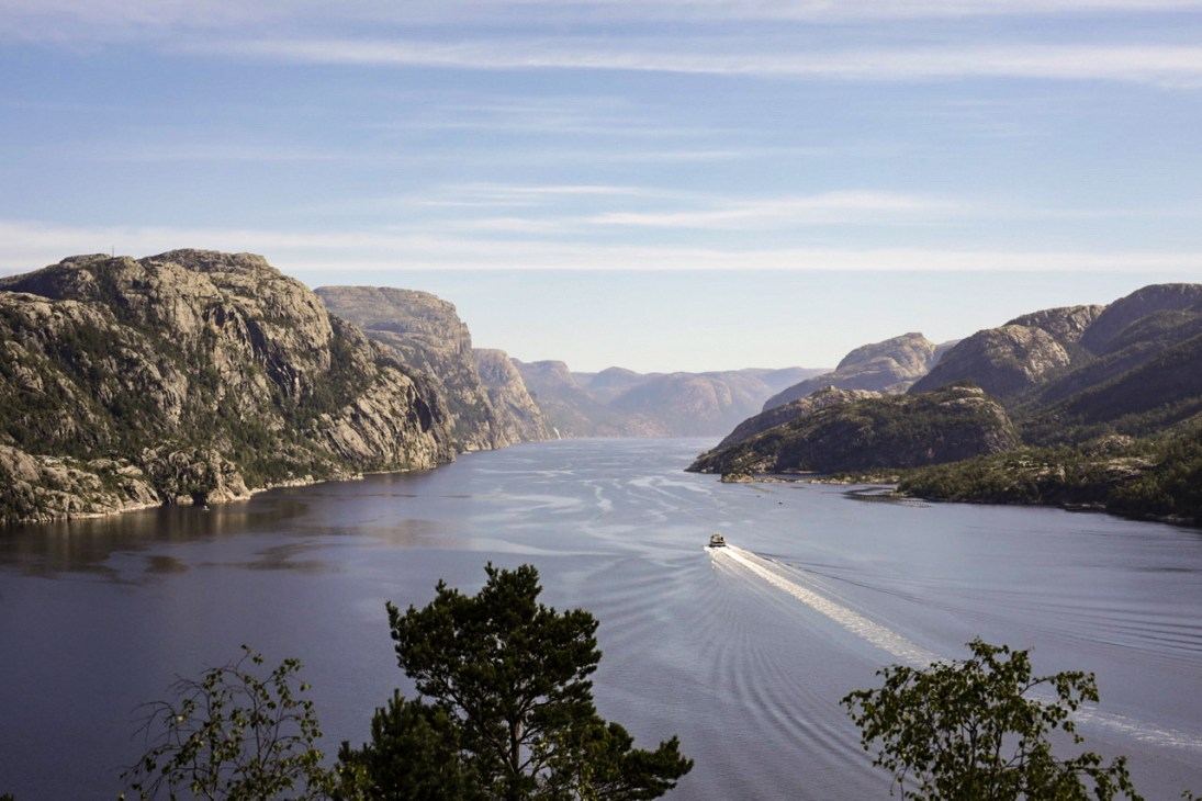 Electric ferry navigating through dramatic Norwegian fjord landscape