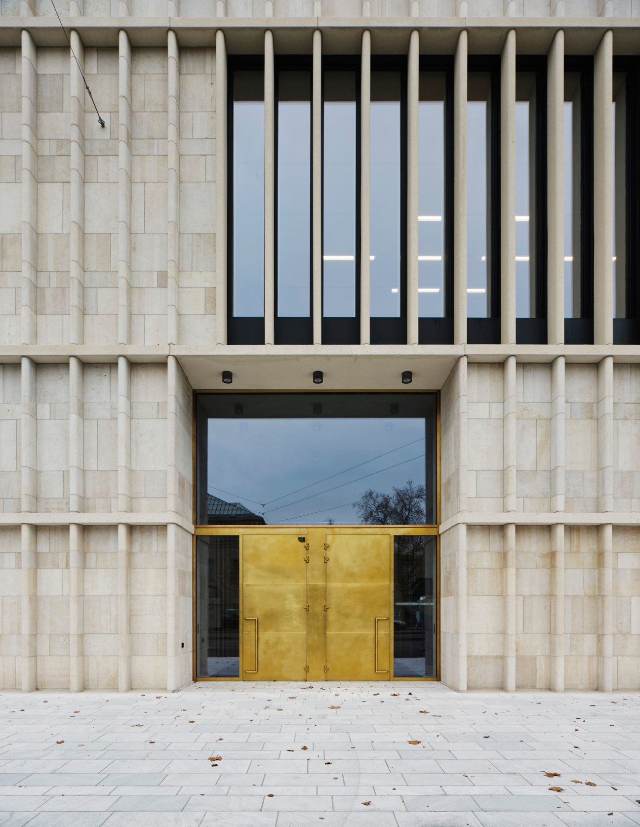 Museum interior showing concrete and light oak materials with brass details