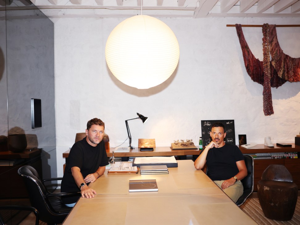 Karl Fournier and Olivier Marty of Studio KO sitting at a conference table in their modern office workspace