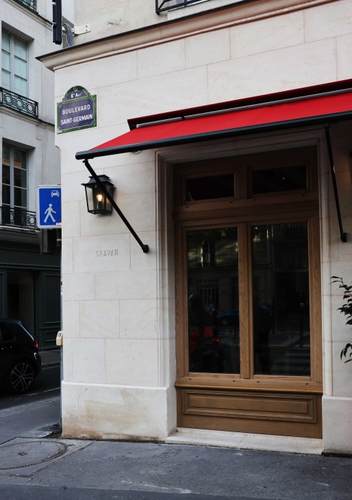 Understated exterior entrance to Cravan bar on Boulevard Saint-Germain with traditional French architecture
