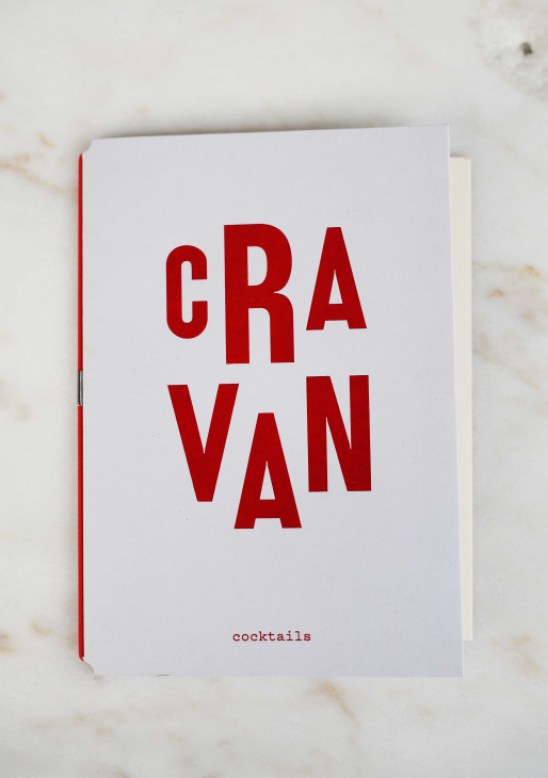 Close-up view of Cravan's elegant cocktail menu with artistic typography and drink listings