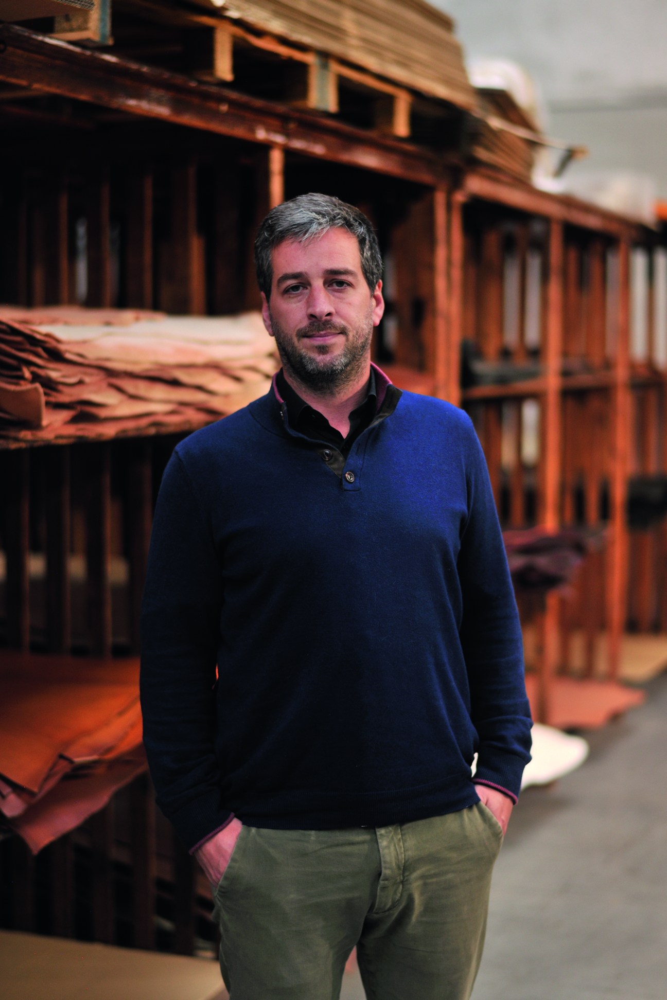 Nicolas Quintin stands in front of wooden shelving in what appears to be a workshop or storage area
