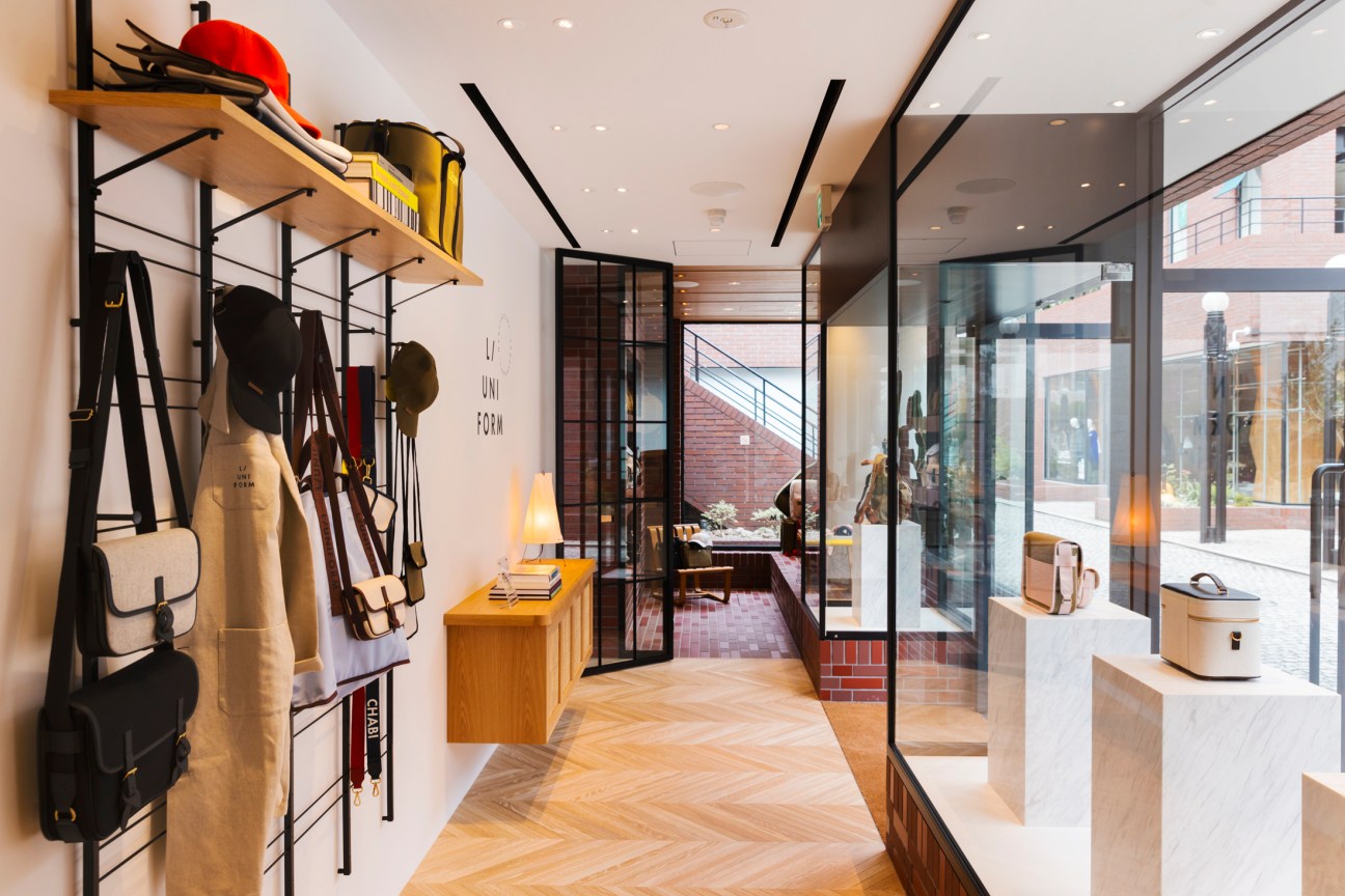 Interior of L/Uniform's new Tokyo flagship store showing Japanese-French design fusion with paper lanterns and wooden furniture