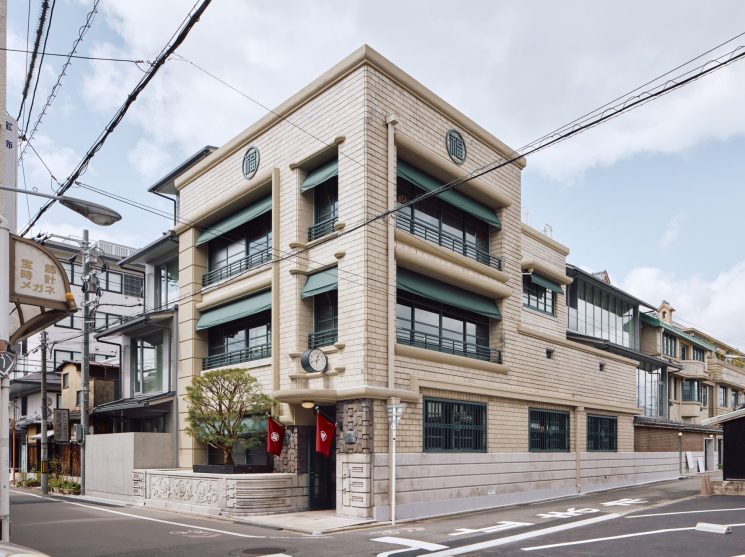 Art deco facade of Marufukuro hotel in Kyoto showing restored 1930s architecture with green awnings