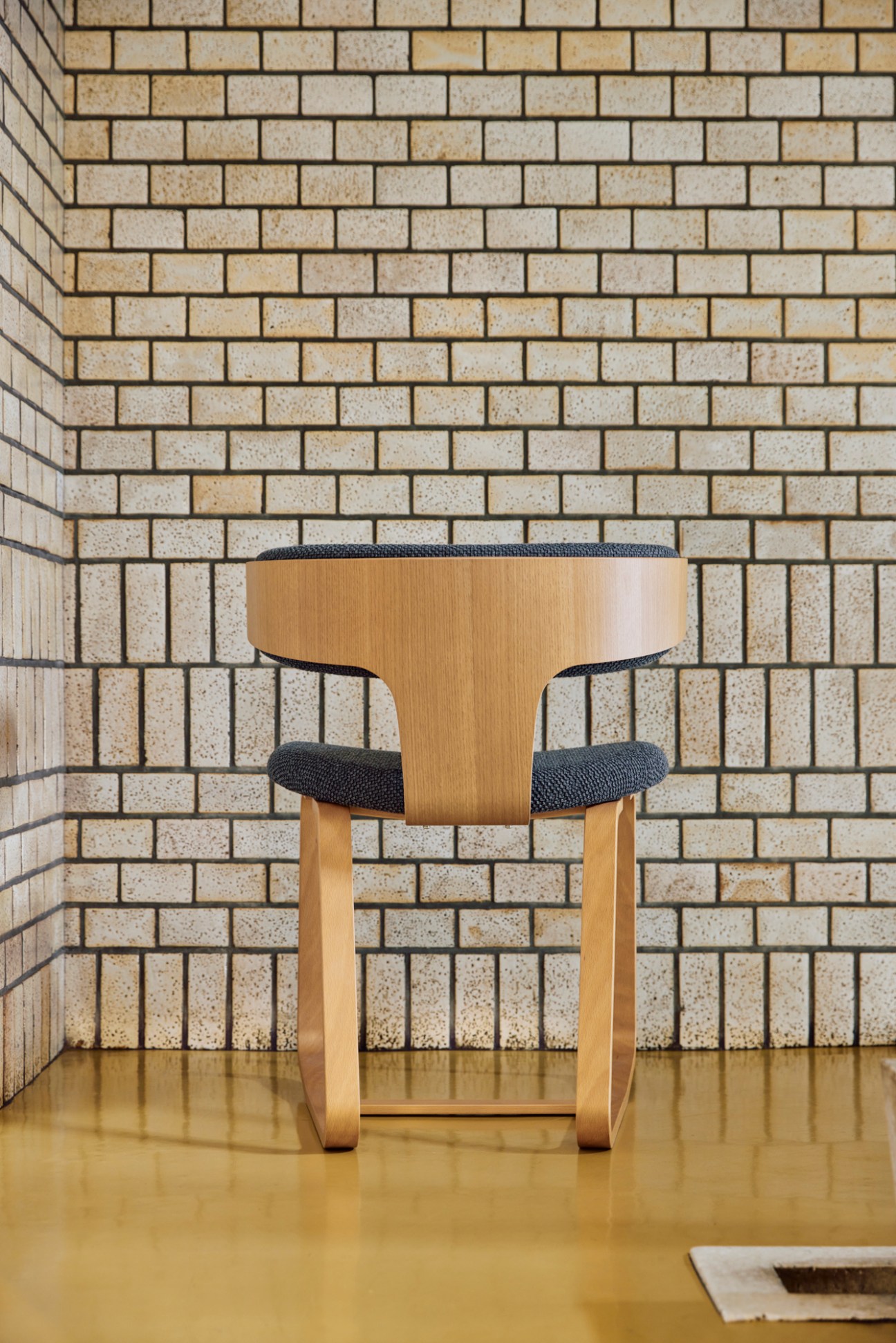 Close-up detail of Tendo chair craftsmanship showing precision moulded plywood joinery and textile upholstery