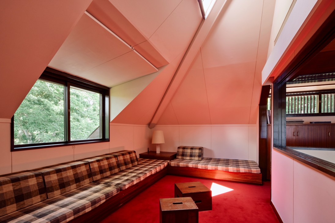 A dramatic skylight casting natural light onto a vibrant red Yamagata Dantsu carpet below