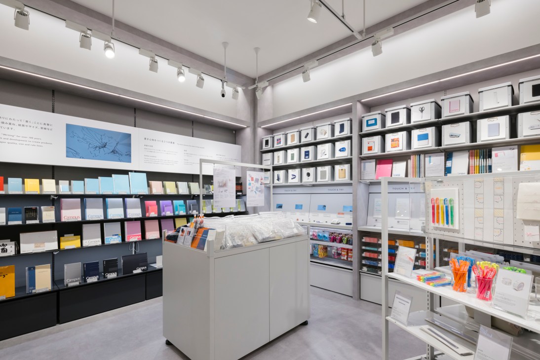 Interior view of Kokuyo Doors stationery shop showing modern white display shelving with organized office supplies
