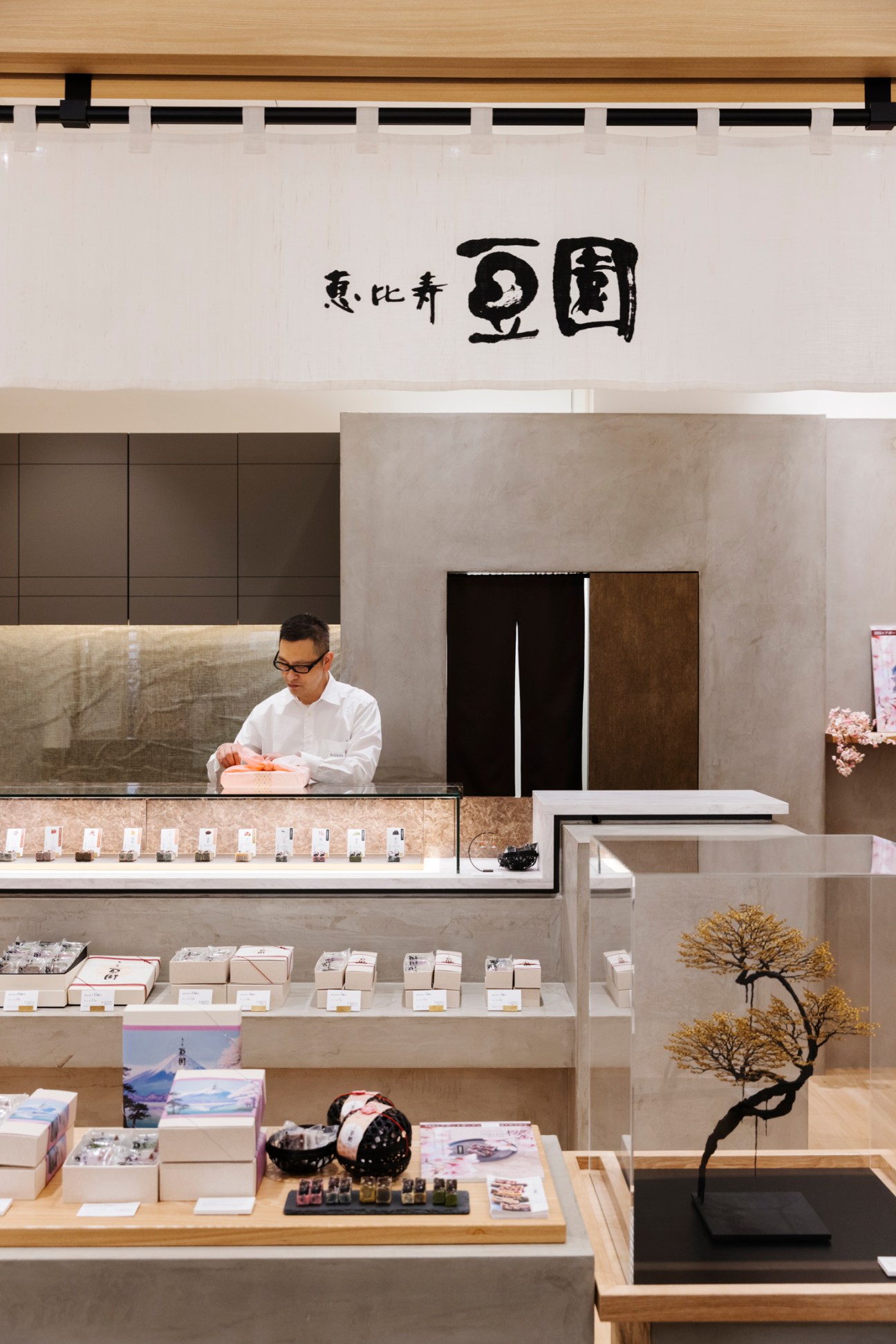 Service counter at Mamezono confectionery shop with staff member and display case