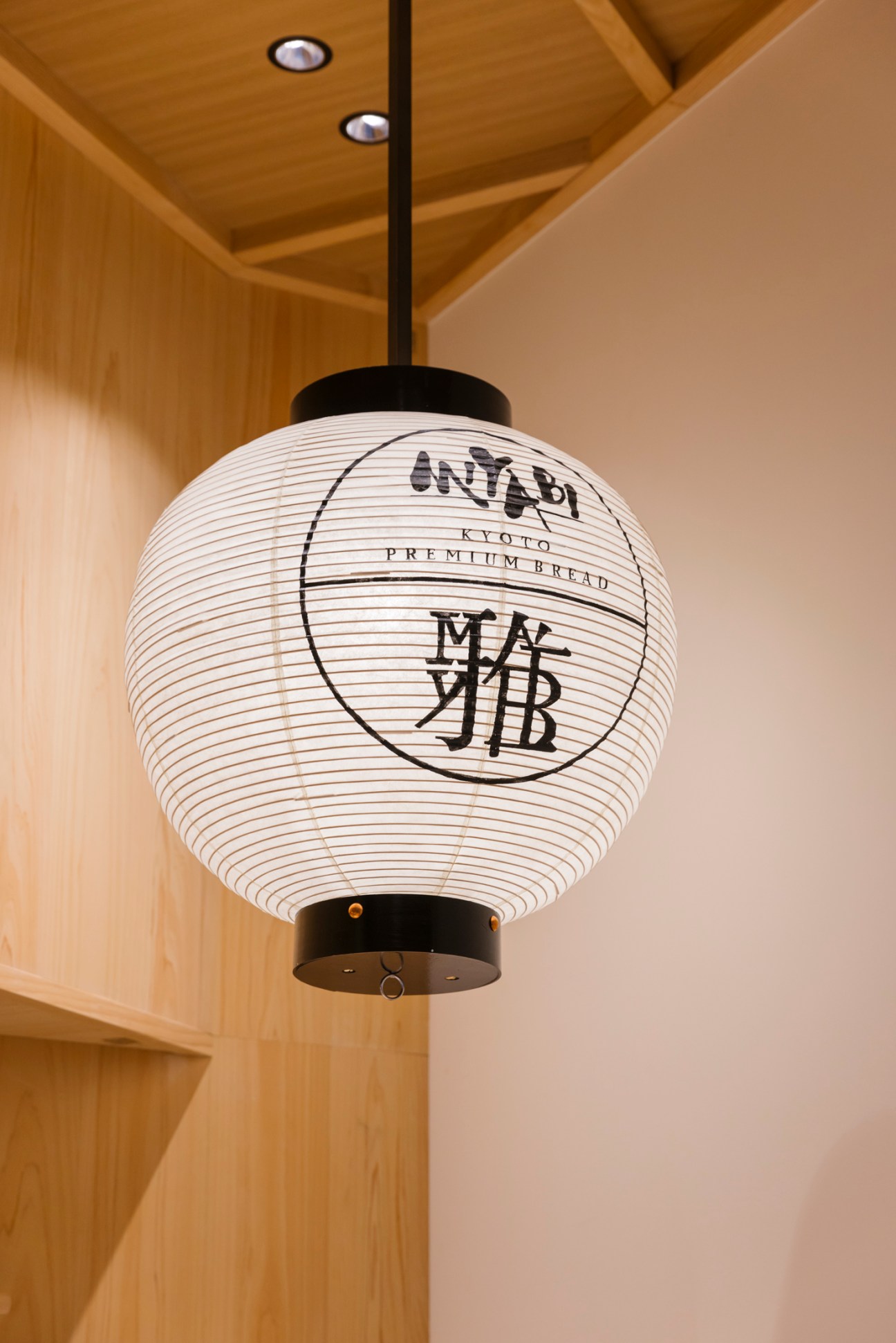 Traditional white Japanese paper lantern with Miyabi Kyoto Premium Bread branding hanging in wooden interior