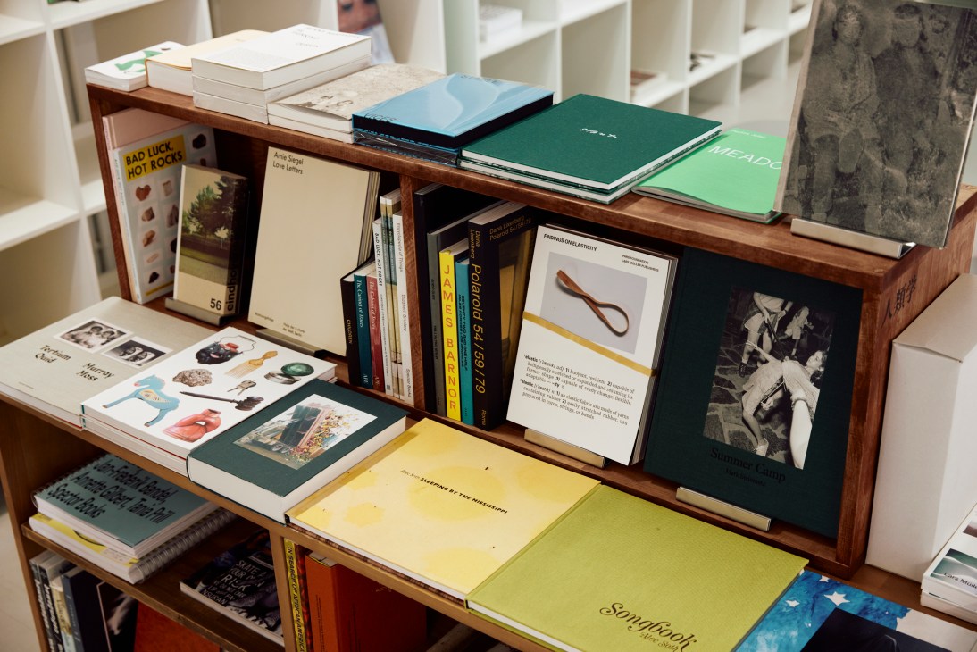 Interior view of Shinkenchiku Shoten bookshop with wooden shelves displaying architecture books