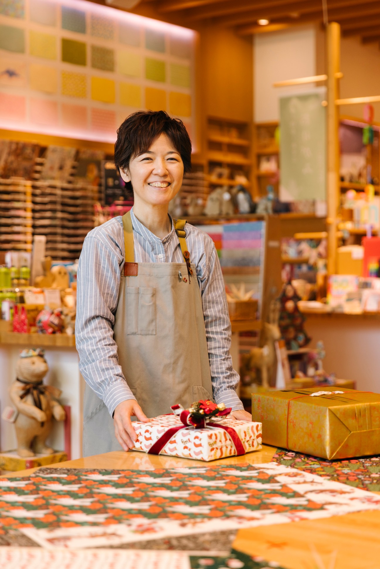 Sayaka Takagi smiling behind a counter with wrapped gifts at Itoya's Ginza store