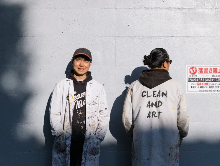 Ken Sobajima and Hisayoshi Yamauchi from Clean and Art in white lab coats standing against a wall in Tokyo