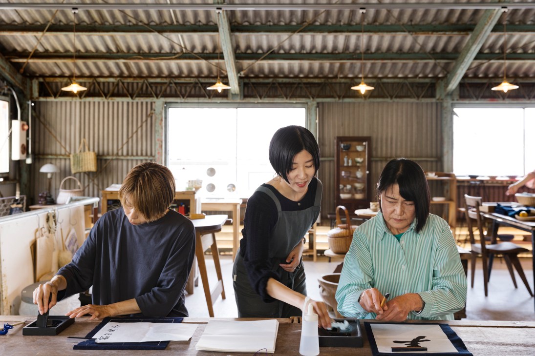 Kanoko Nakashima instructing students in traditional Japanese calligraphy at workshop table
