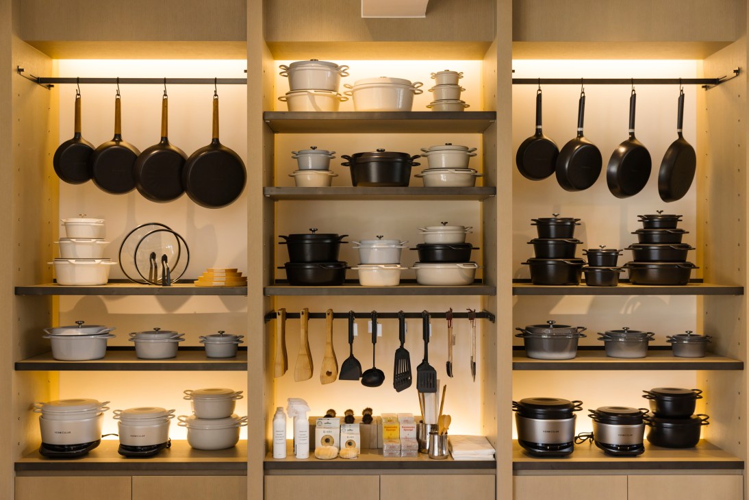 Interior of Vermicular shop displaying colorful cast iron pots, rice cookers and frying pans on wooden shelving