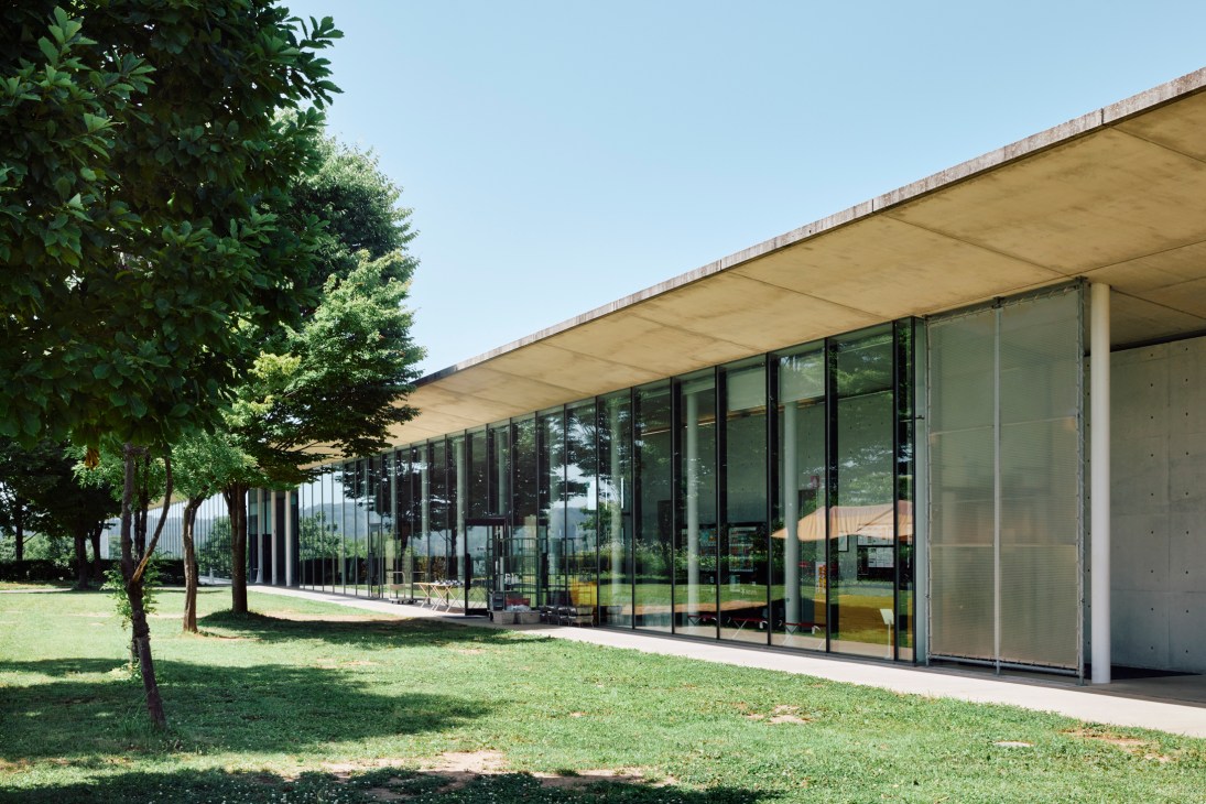 Snow Peak headquarters building surrounded by lush green forest landscape