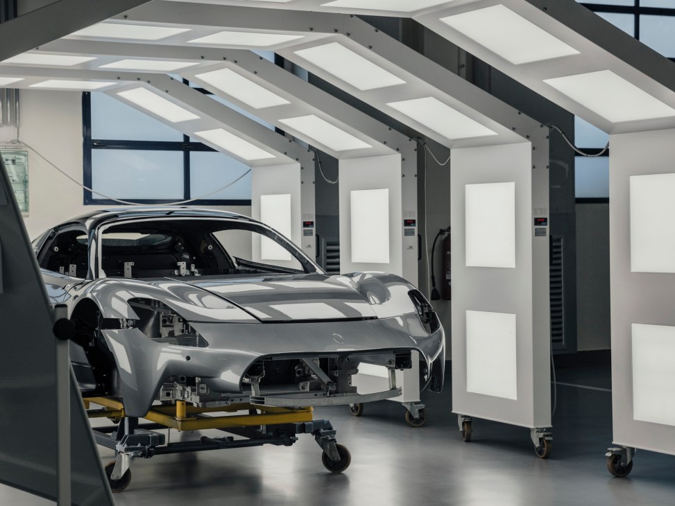 Car body shell on wheeled assembly line in modern automotive manufacturing facility