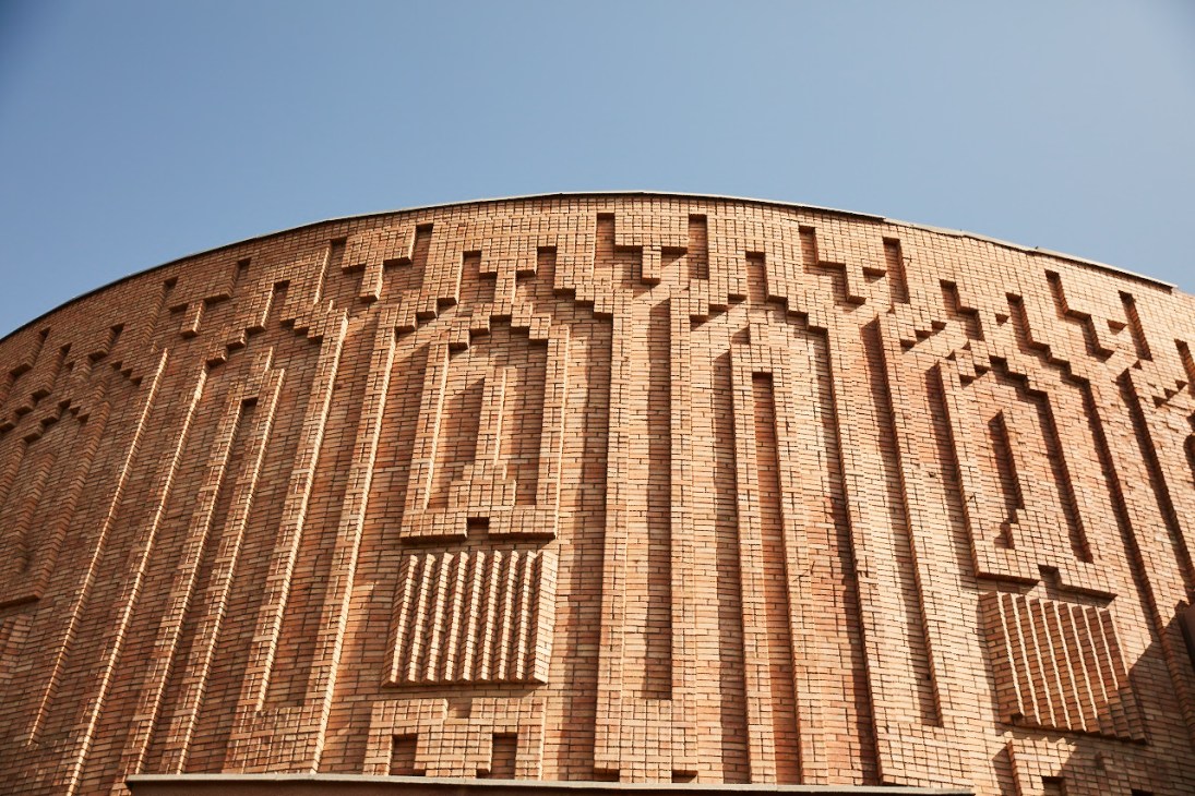 Curved brick building with geometric patterns and decorative elements in modernist architectural style