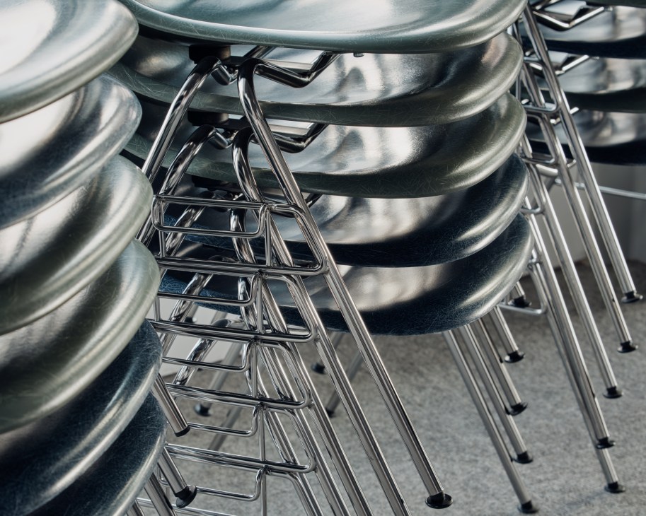 Stack of modern molded plastic chairs in various colors arranged vertically