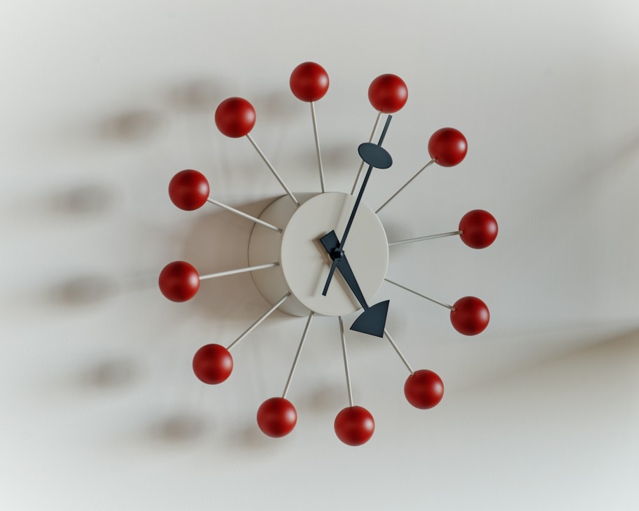Nelson Ball Clock with red spherical elements on white spokes radiating from white center with black hands