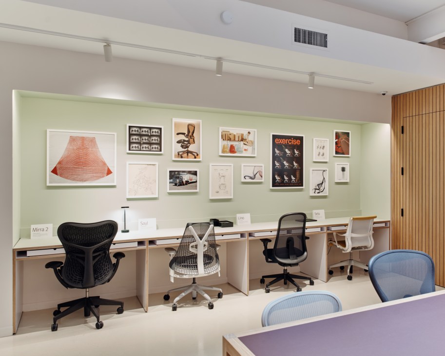 Employee working at laptop in modern retail showroom environment with furniture displays