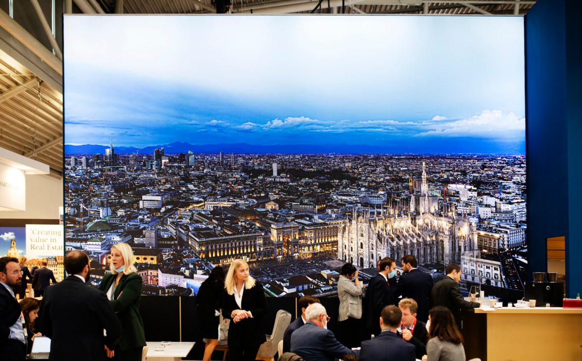 Large display showing Milan city skyline with Gothic cathedral at trade fair exhibition booth