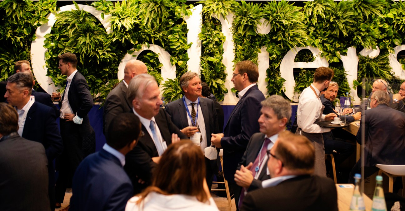 Conference delegates gathering and networking at the exhibition stall of Colliers property agents
