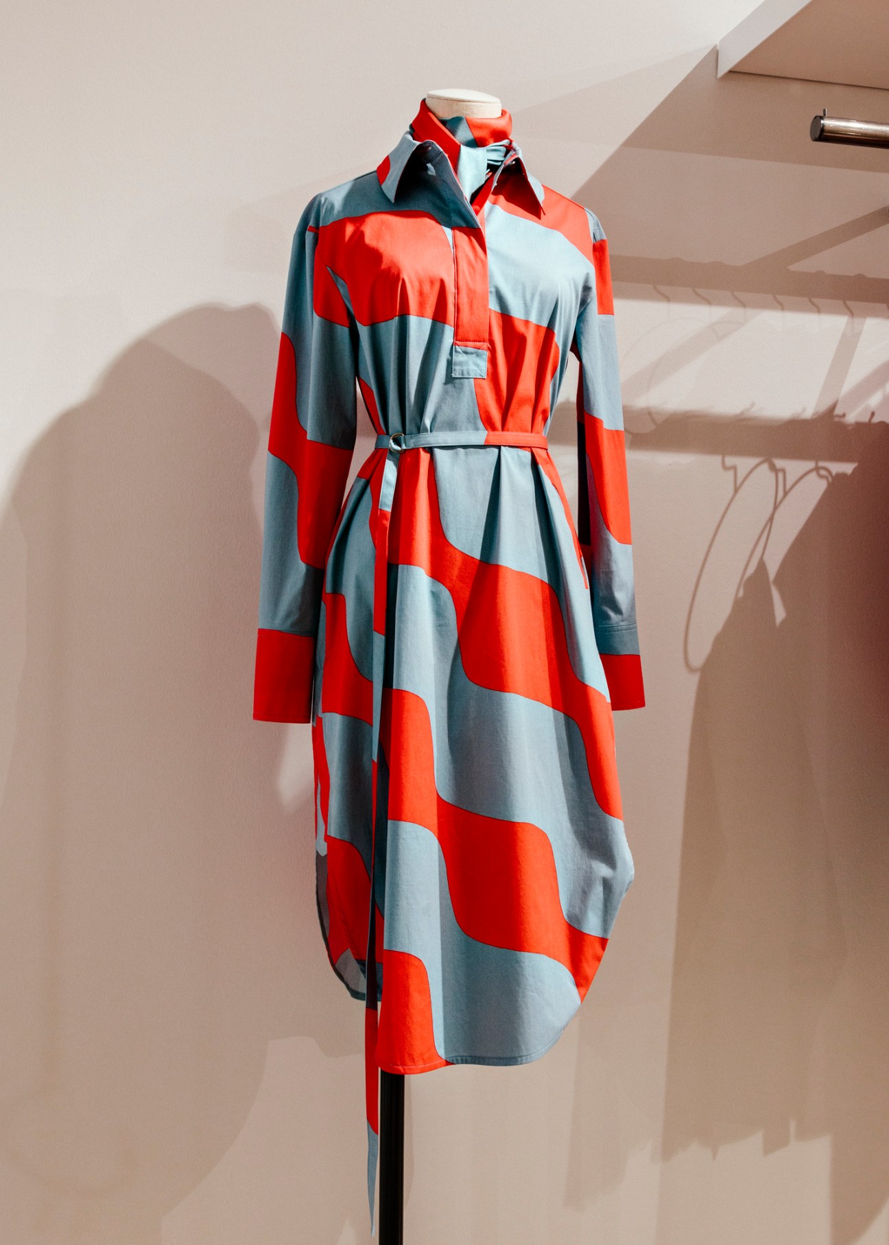 Woman in red and blue geometric print shirt dress with belt, displayed on mannequin