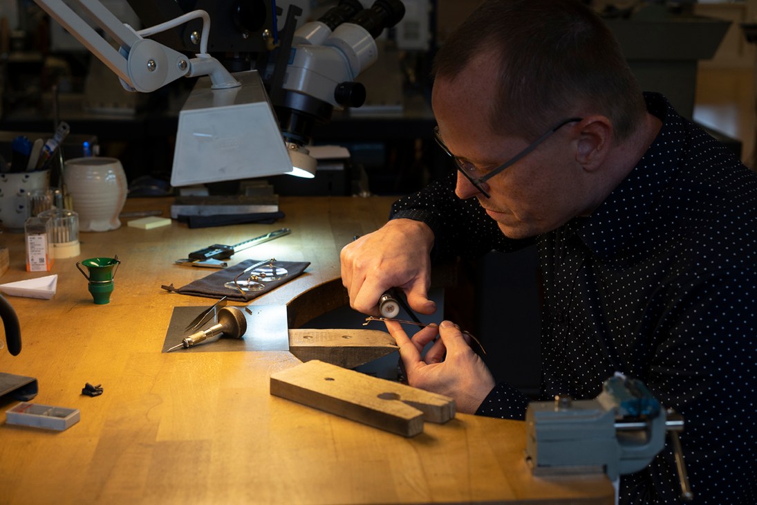 A craftsman uses precision tools to assemble eyewear components at a Lindberg workshop in Aarhus, Denmark.
