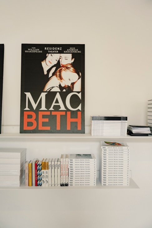 Poster for Macbeth at Residenz Theatre displaying bold typography and portraiture on a black background with orange text.